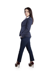 Elegant and confident office worker woman in a business suit, standing in heels. In the studio on white background