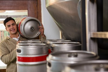 Portrait of male worker carrying keg