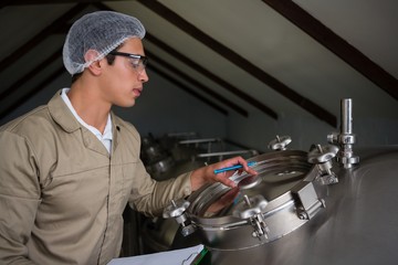 Worker examining storage tank