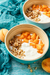 Homemade yogurt with granola, apricot and pine nuts