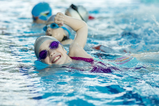 happy children kids group at swimming pool class learning to swim