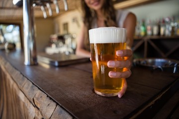 Barmaid holding beer glass