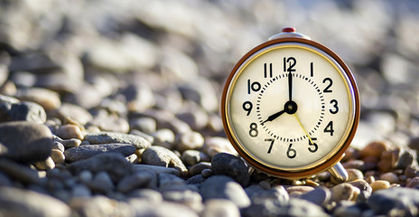 Time concept - website banner of an alarm clock on the beach