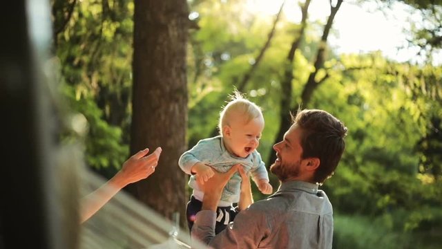 Happy family is having fun in the park and playing with cute baby