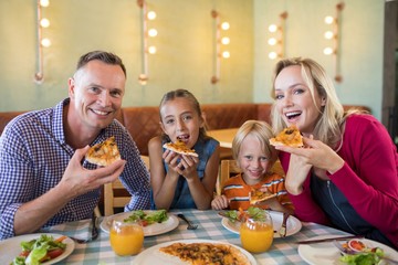 Portrait of happy family having pizza