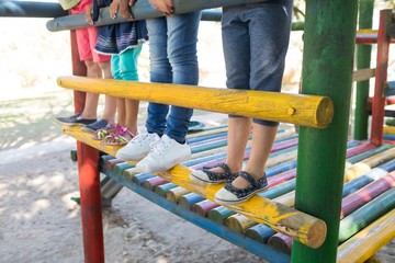 Low section of children standing on jungle gym