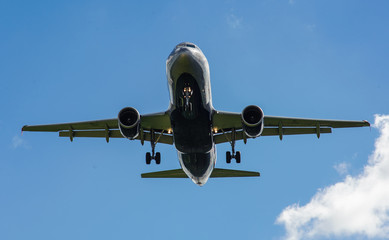 The plane on a background of blue sky and white clouds.