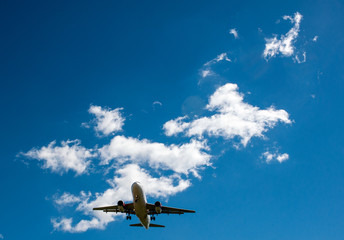 The plane on a background of blue sky and white clouds.