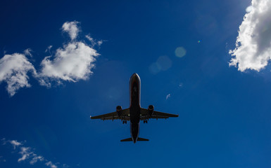 The plane on a background of blue sky and white clouds.