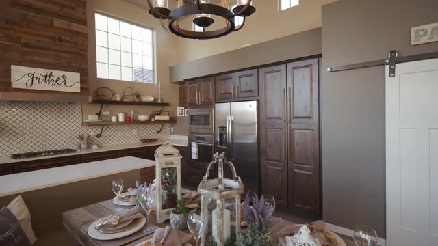 Lowering from Corner of Kitchen to Dining Room Table. shot lowers from corner of modern kitchen to reveal place settings on a wood dining table
