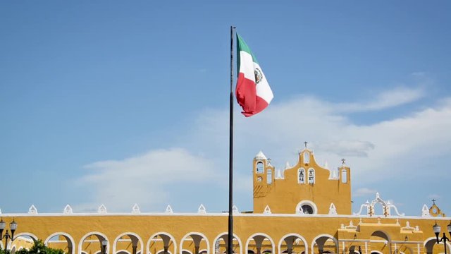 Mexican flag waving in front of the monastery in Izamal, Mexico