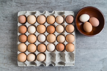 Crate of eggs with three in a bowl