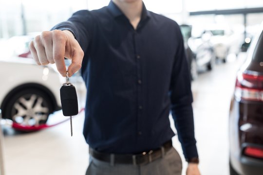 Midsection of salesman showing car keys