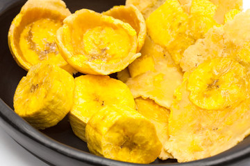 Raw plantain cups, patacones and pieces on white background