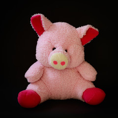 pink pig doll on black background, isolated