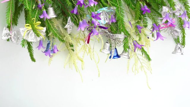flutter on a wind christmass tree brunches frame in a row decorated with a bells above, copy space for your text at the bottom. new year and christmas conceptual greeting card.
