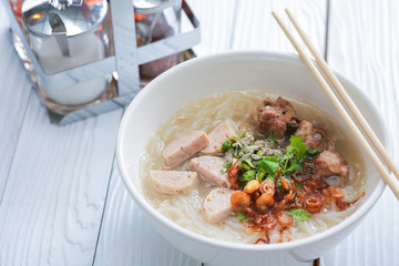 Vietnamese noodle soup on white wooden table.