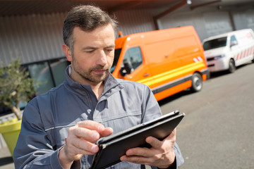 worker writing on clipping board outside