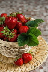 Fresh Strawberries with leaves in the basket on the table. Vertical view. Organic farmer berries.