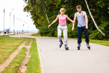 Active young people friends rollerskating outdoor.