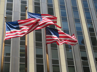 American flags flying in front of a skyscraper