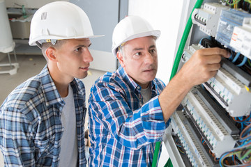 electrician workers switching on in fuse board