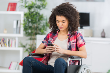 disabled woman in wheelchair on mobile phone - Powered by Adobe