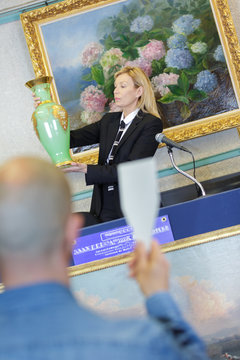 woman auctioneer and man negociating price of item