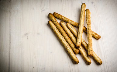 rustic breadsticks on wood table, close up, background.
