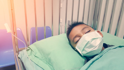 The boy is wearing a nasal discharge, is sleeping, and gives saline solution in hospital bed-health...