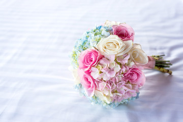Beautiful bouquet of roses on the white bed.