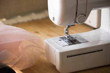 Studio dress designer. Sewing machine and lace on the table.