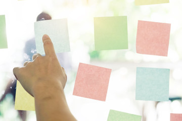 Obraz premium Sticky note paper reminder schedule on window. Use post it notes to share idea on sticky note. Discussing - business, teamwork, brainstorming concept with film vintage tone.