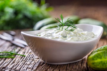 Tzatziki. Traditional greek dip sauce or dressing tzatziki prepared  with grated cucumber sour cream yogurt olive oil and fresh dill. Mediterranean cuisine.