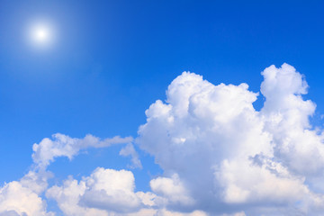 Naklejka na ściany i meble Blue sky background with white clouds and sunshine on sunny summer or spring day.