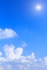Blue sky background with white clouds and sunshine on sunny summer or spring day.