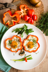 Funny face made of fried eggs, peppers, onions and mushrooms on a plate