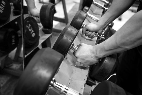 Black and white images Hand holding dumbbell in the gym bodybuilding.