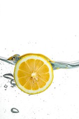 Lemon falls into the water with bubbles