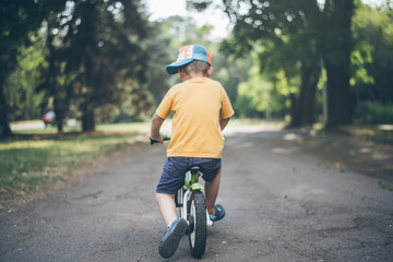 Obraz premium young boy riding strider bike