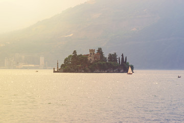 Lake Iseo and the small island of Loreto in the rays of the setting sun, Lombardy, Italy