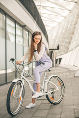 Fototapeta na wymiar Full length shot of a beautiful young businesswoman with her bike going to work. Beauty with white vintage bike.