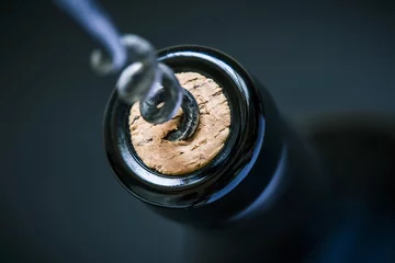 Rolgordijnen wine cork in bottle and corkscrew and blurry background, photographed from above for winemaker business card or book cover © zozzzzo