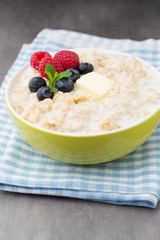 Oatmeal porridge in bowl with berries raspberries and blackberries.