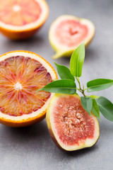 Mixed citrus fruit figs, limes on a gray background.