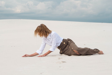 The girl crawls through the desert with her last strength