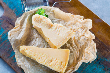 Traditional Italian hard cheese Parmesan and Grana Padano with grater and fresh basil