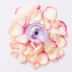 Perfume bottle with flower petals on light background. Perfumery, fragrance collection. Women accessories.