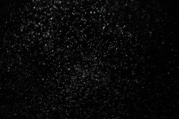 Snowstorm texture. Bokeh lights and Falling snow on a black background for use as a texture layer...