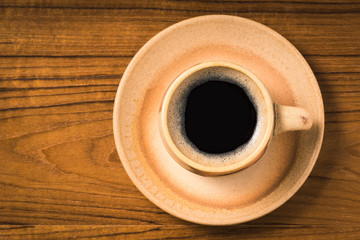 top view of espresso coffee cup on wooden table top, vintage color tone